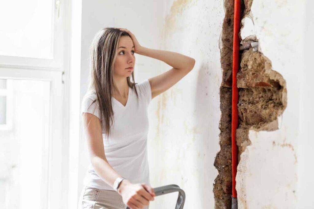 Woman Looking At Damage After A Water Pipe Leak