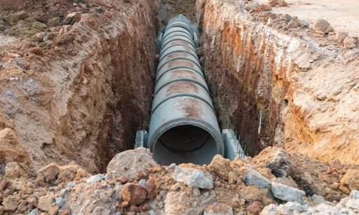 concrete drainage pipe being installed 